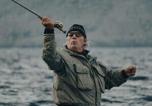 An experienced angler skillfully casting a fly fishing line, demonstrating precision and technique in open water.